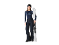 Vrouw in ski-uitrusting, inclusief broek, top en skibril, met ski's.
