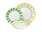 Wit servies met gele en teal handgeschilderde patronen, inclusief borden en een kom.