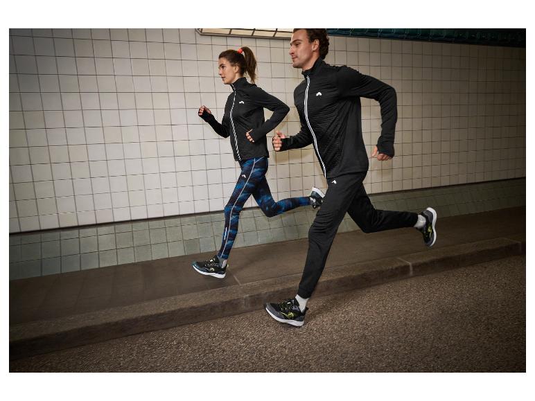 Twee hardlopers in zwarte en blauwe sportkleding, in een tunnel.