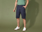 Man draagt blauwe cargo shorts en witte sneakers.