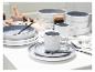Wit en grijs keramisch servies met mokken, kommen en borden, zwart bestek en glazen.