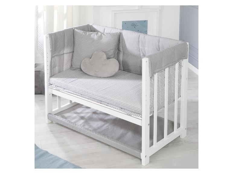 Wit ledikant met grijs-wit geruit beddengoed en een wolk-vormig kussen.