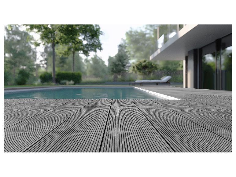 Grijze composiet vlonder bij een zwembad met een modern huis op de achtergrond.