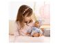 Meisje in roze top houdt babypop vast in pyjama met patroon en muts.
