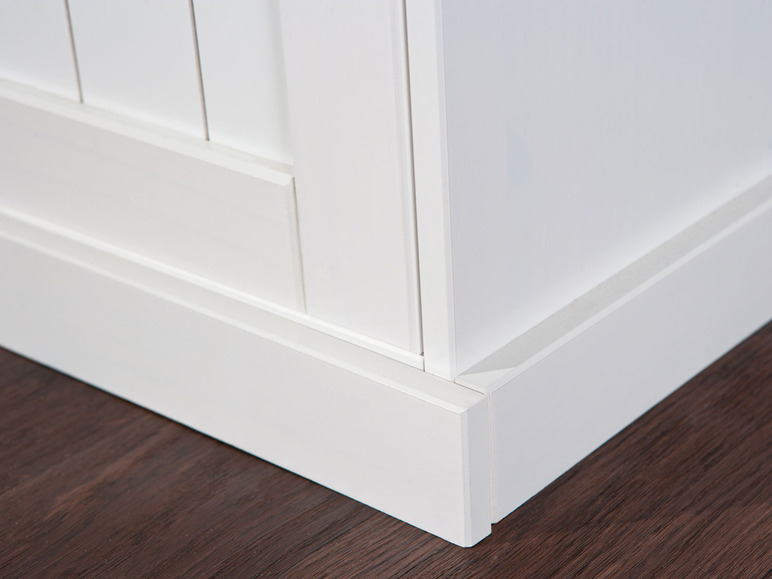 Witte plint langs een houten vloer.