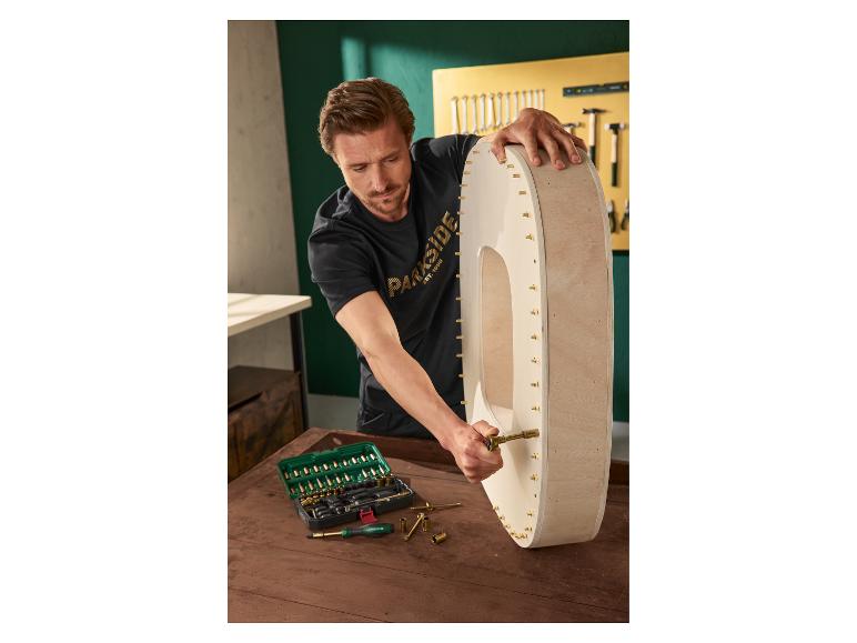 Man monteert houten wanddecoratie met gereedschapset.