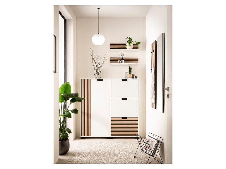 Halmeubel met schoenenkast, planken en spiegel in wit en hout, met planten en decoratie.