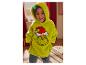 Lachende jongen in een pluizige groene Grinch hoodie, binnen.