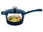 Blauwe steelpan met een uitsparing die courgettenoedels met cherrytomaten en pijnboompitten toont.