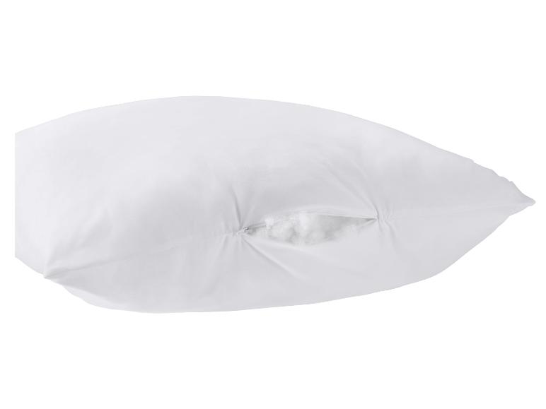 Wit kussen met open rits, die de pluizige vulling onthult.