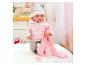 Babypop in roze hoodie en bedrukte broek, met deken, fles en speen