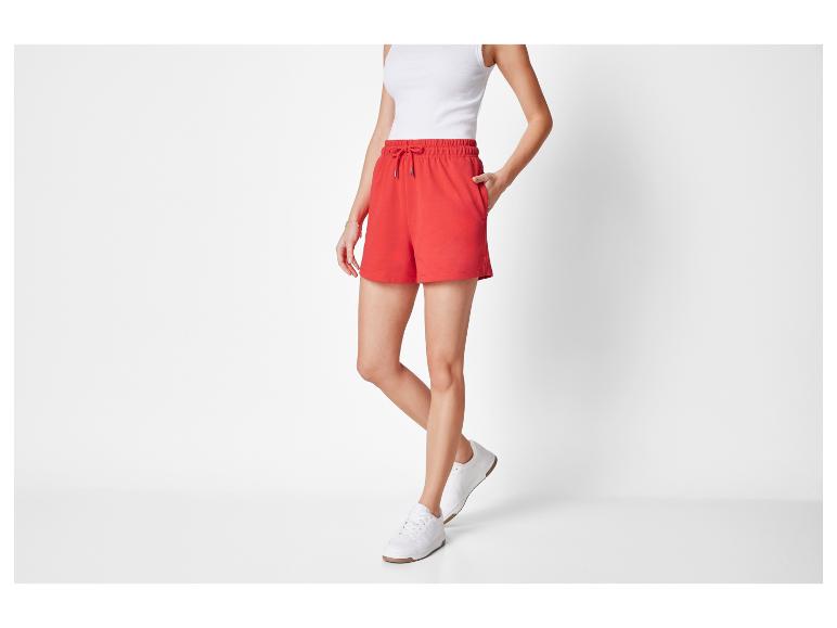 Rode shorts en witte sneakers voor dames.