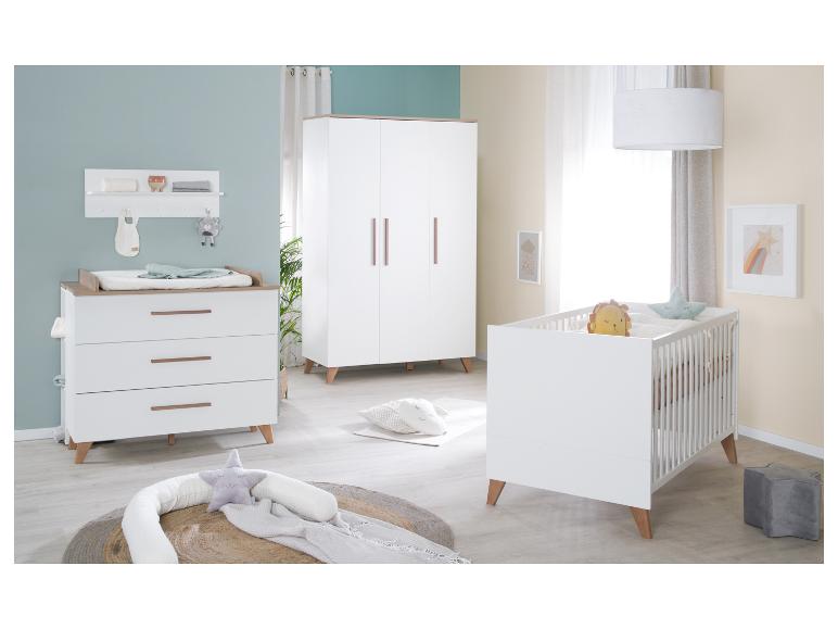 Moderne babykamer met wit ledikant, commode en kledingkast.