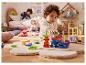 Een kind speelt met houten speelgoed op een zacht tapijt in de kinderkamer.