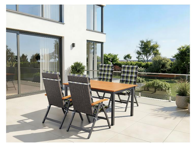 Terras eethoek met een houten tafel en vier stoelen met geruite kussens op een modern terras.