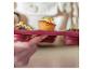 Persoon houdt bakvorm met mini cupcakes versierd met chocolade, noten en citroenschil vast.