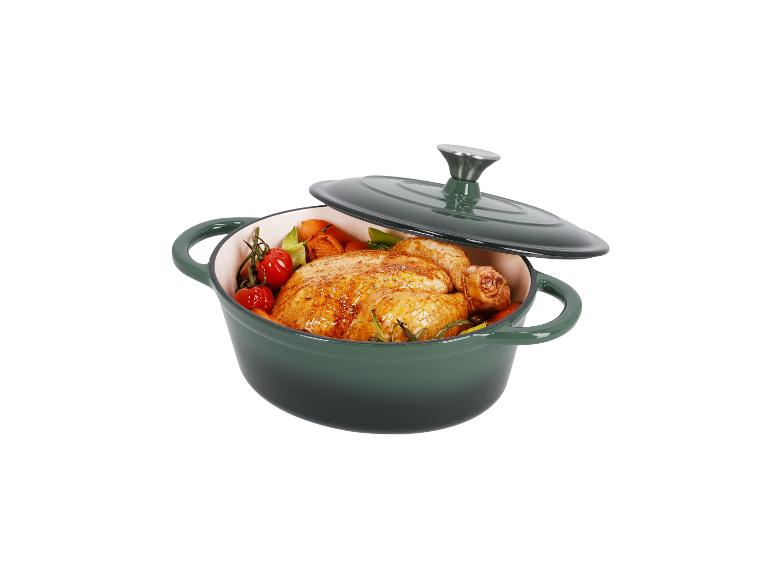 Een gebraden kip met groenten in een groene gietijzeren pan.