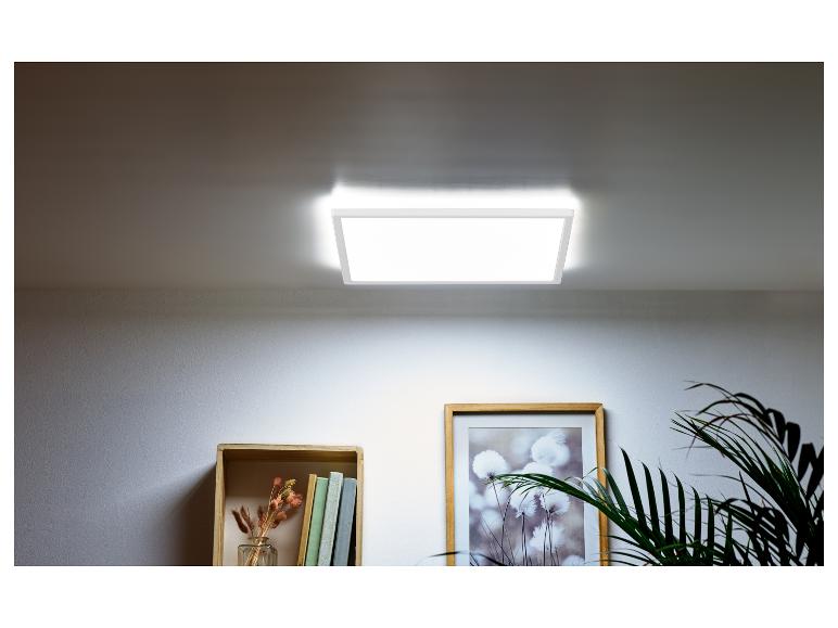 Vierkante LED-plafondlamp verlicht een kamer met een plank en een plant.