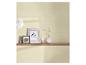 Lichtbeige behang met een houten plank, decoratieve lijsten en een witte vaas.