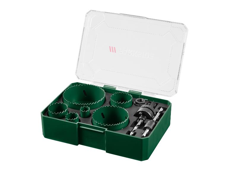 Groene gatenzaagset en accessoires in een transparante plastic doos.