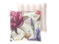 Twee decoratieve kussens: één met bloemenpatroon, de andere met roze en witte strepen.