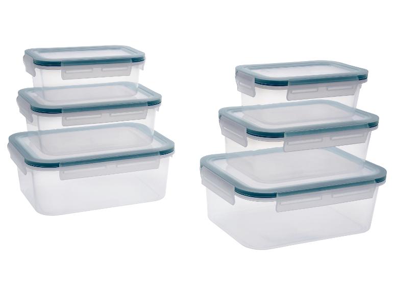 Transparante voedselcontainers met blauwe deksels, gestapeld in twee hopen.