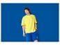 Man in geel T-shirt en blauwe korte broek met Lidl-logo.