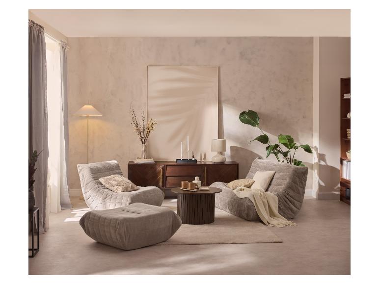 Woonkamer met twee grijze fauteuils, een bijpassende poef, een houten salontafel en een dressoir.