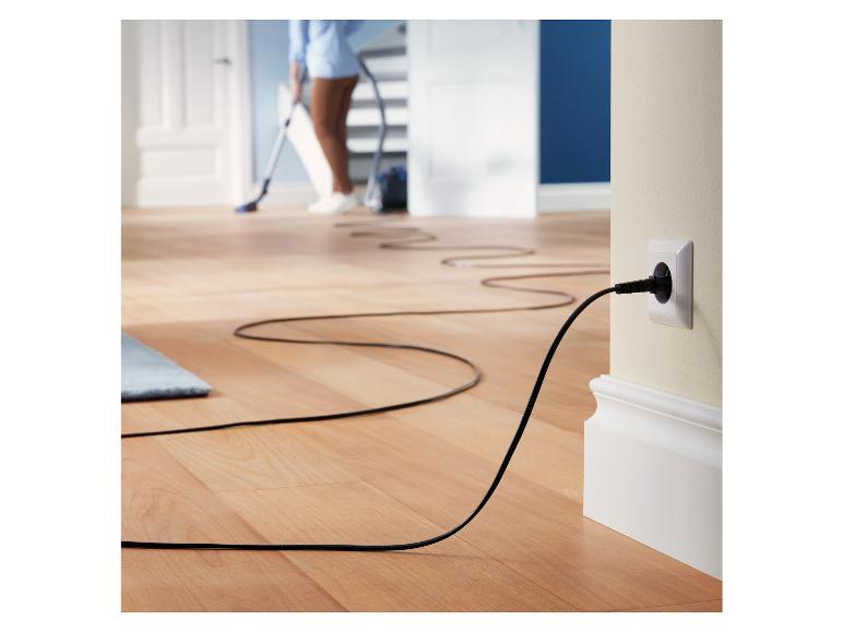 Een zwarte snoer van een stofzuiger, aangesloten op een stopcontact.