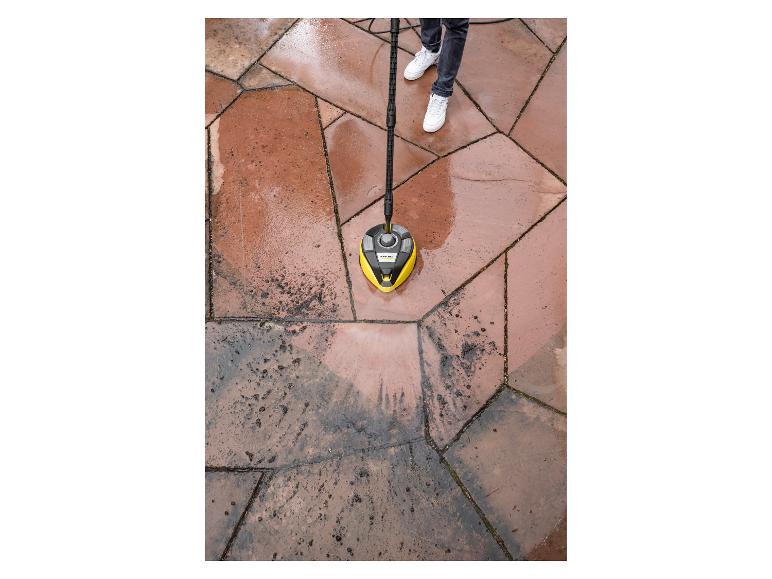 Bovenaanzicht van een persoon die een terras reinigt met een hogedrukreiniger oppervlaktereiniger, met schone en vuile gedeelten.