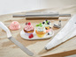 Een roldeeg, spuitmondjes en cupcakes met verschillende versieringen.