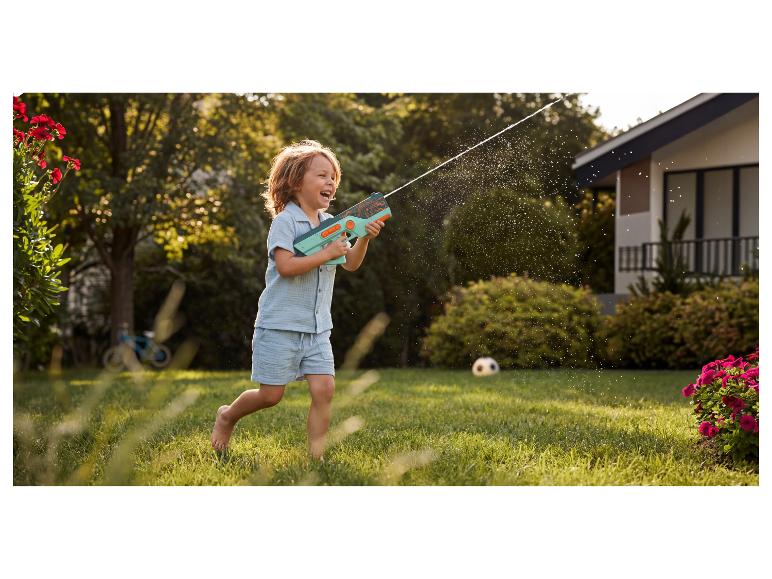 Blij kind speelt met een waterpistool in de tuin.