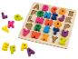 Houten puzzel met felgekleurde alfabetletters, sommige buiten het bord.