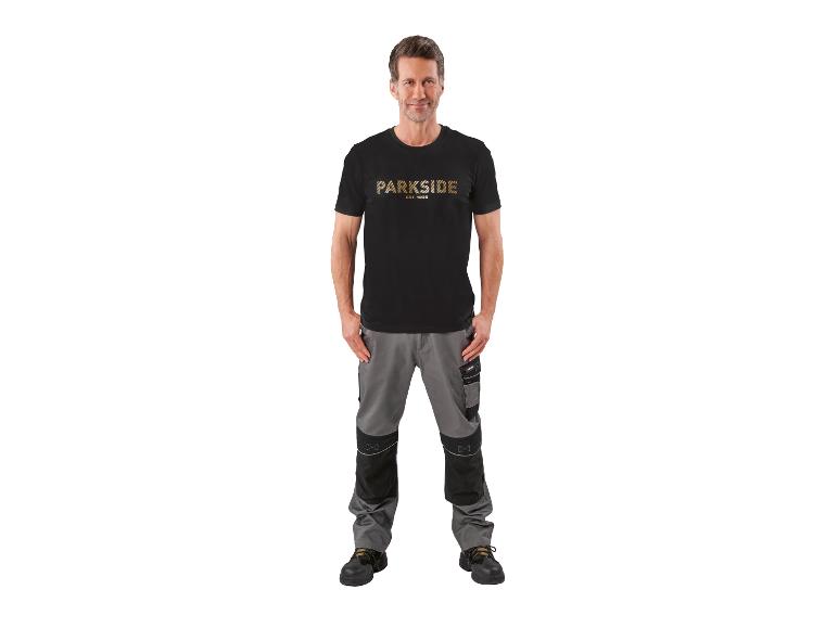 Man in zwart T-shirt met tekst en grijze werkbroek