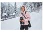 Vrouw in roze CRIVIT Thermo-Softshelljas met verrekijker in besneeuwd landschap.