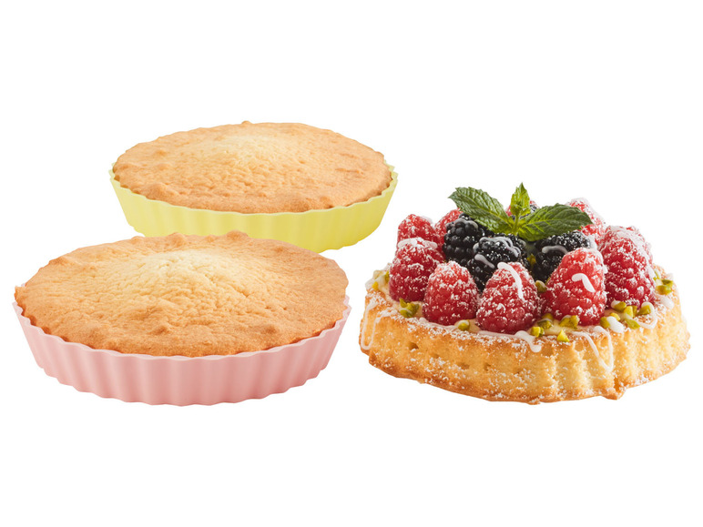 Twee taartvormen en een taart met frambozen en bramen.