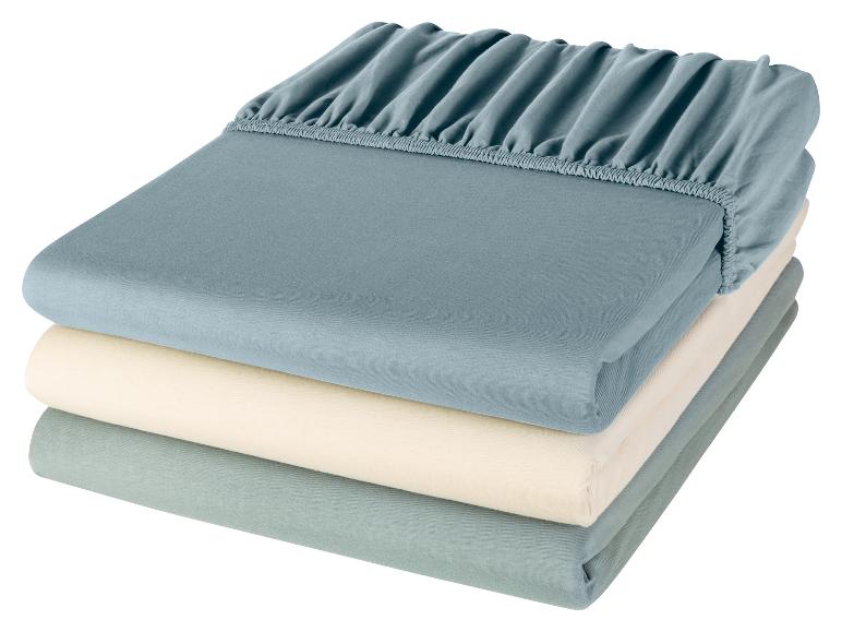 Een stapel bedlakens in verschillende kleuren.