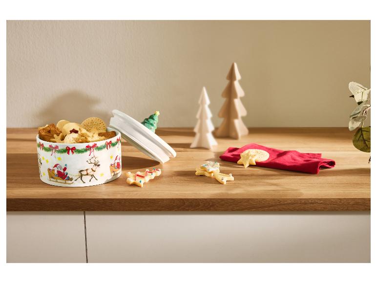 Kerstkoekblik met diverse koekjes en feestelijke decoraties.