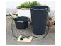 Watersysteem met boormachine, slang en twee waterbakken voor het pompen van water uit vaten.