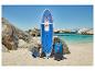 Opblaasbare stand-up paddleboard set met peddel, pomp en rugzak op een zandstrand.