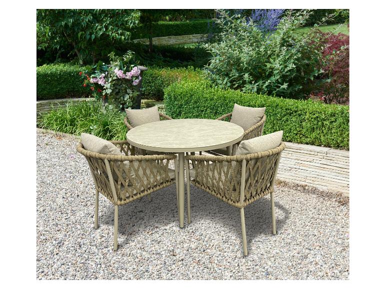 Tuinset met ronde tafel en vier stoelen met kussens op een kiezelpad in een tuin.