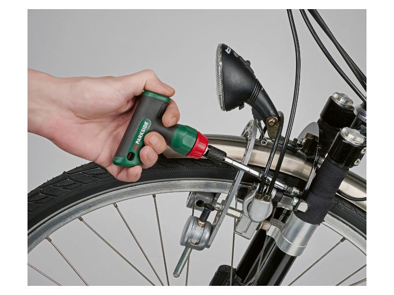 Hand draait een schroef vast op een fiets met een momentsleutel.
