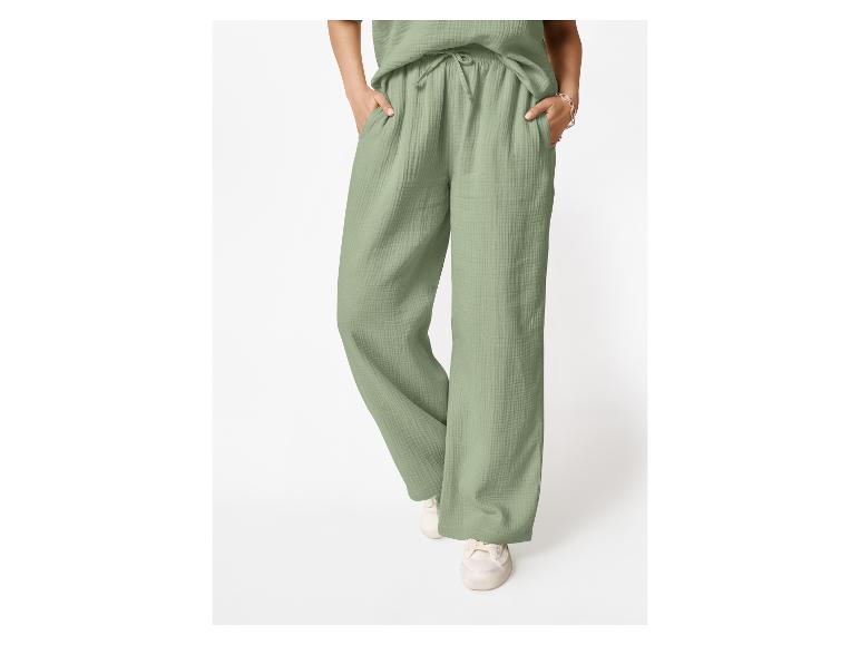 Vrouw draagt lichtgroene wijde broek met trekkoord en bijpassende top.
