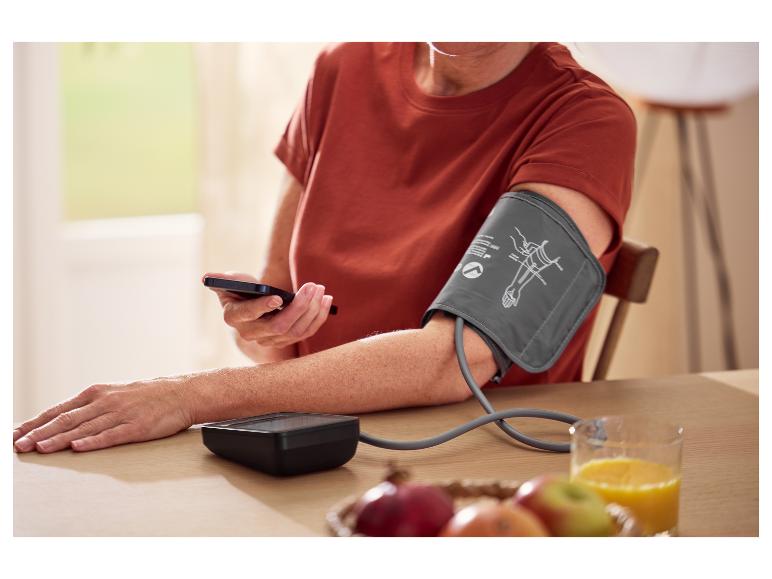 Iemand meet zijn bloeddruk met een digitale bloeddrukmeter.