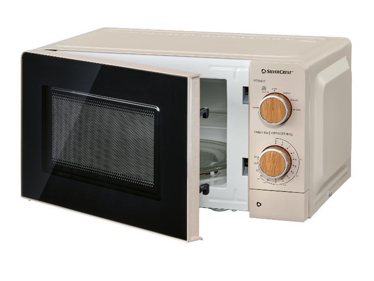 Beige magnetron met open deur en houten knoppen.