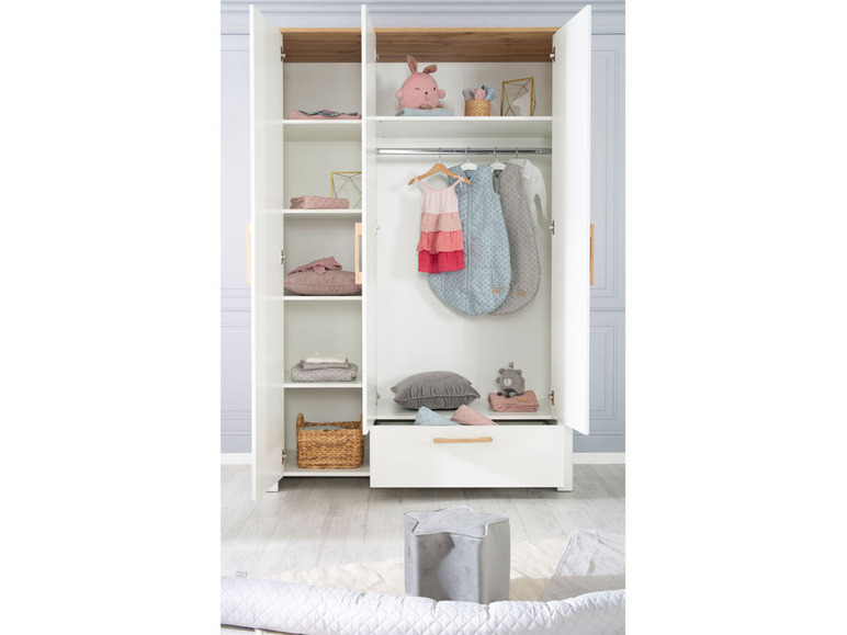 Een witte kledingkast met slaapzakken, knuffels en een mandje