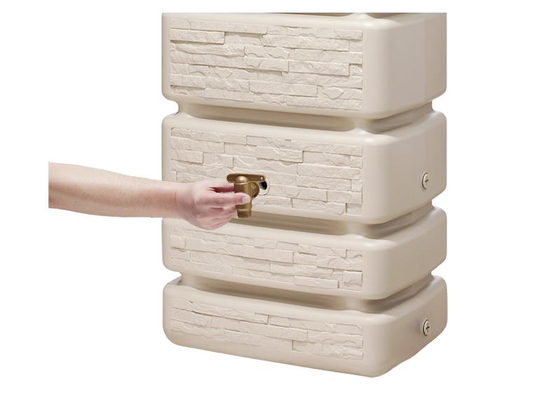 Zandkleurige regenton met een messing kraan en een reliëf baksteenpatroon.