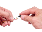 Handen houden draden met gekrompen terminals en een zwarte plastic connector vast.
