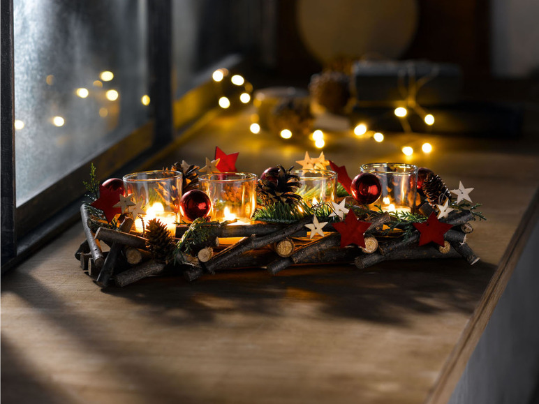 Kerstdecoratie met brandende kaarsen in glazen potten.