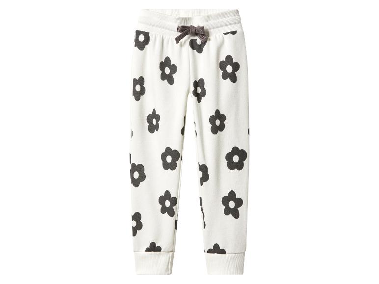 Witte kinder joggingbroek met zwarte bloemenprint en bruin trekkoord.